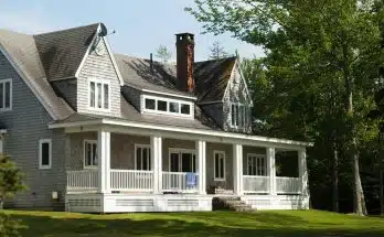 white and brown wooden house near green trees during daytime