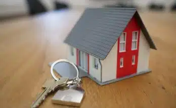 white and red wooden house miniature on brown table