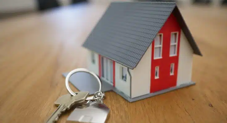 white and red wooden house miniature on brown table